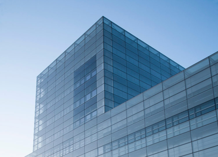 View from the ground of the top of a blue glass office building