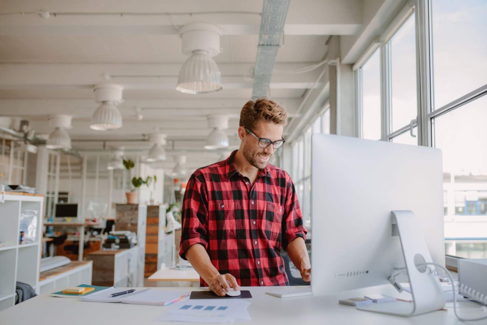 Man in checked shirt looking at computer