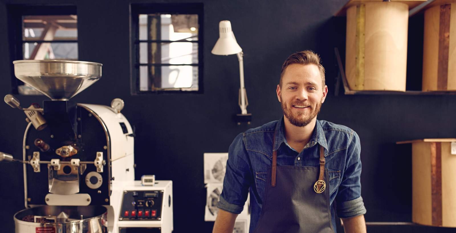 A man leaning backwards on a desk next to a white machine