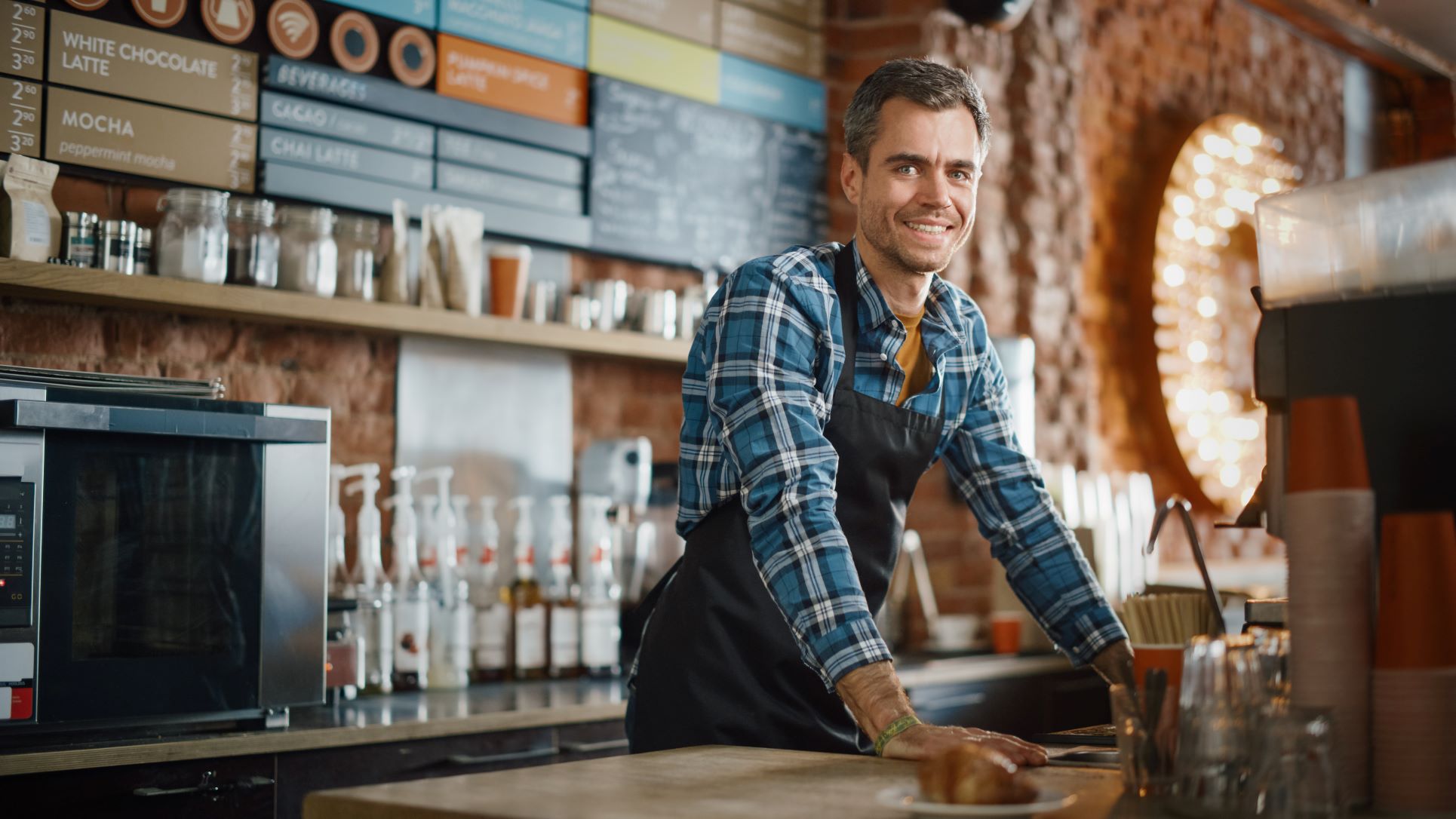 Male barista smiling in a coffee shop