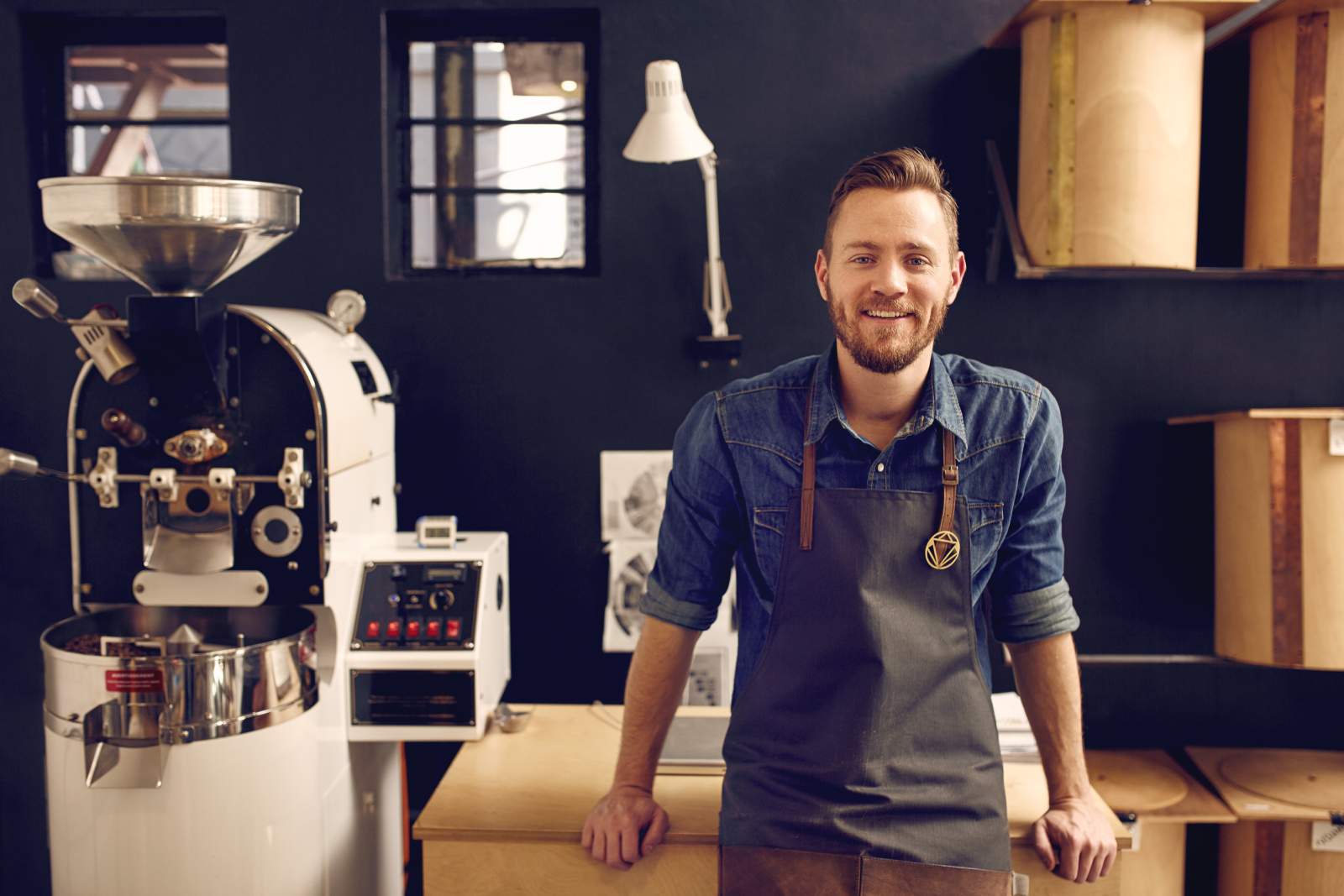 A man leaning backwards on a desk next to a white machine