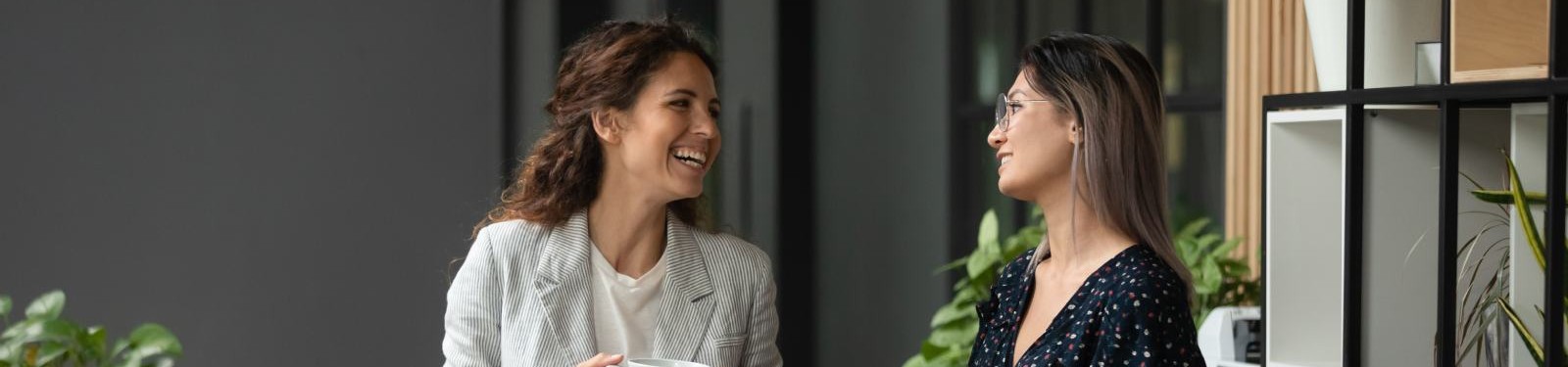 Two women stood chatting in an office walkway