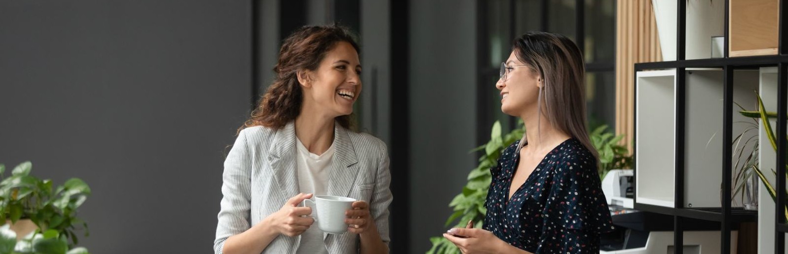 Two women in the office hallway chatting